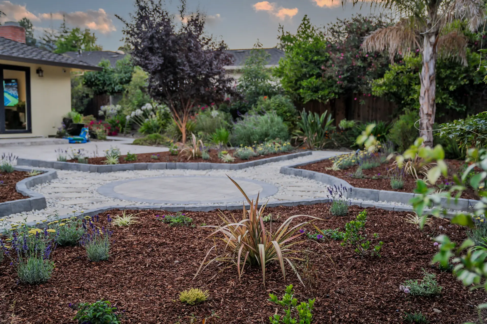 Freshly mulched planting beds beside a stone pathway