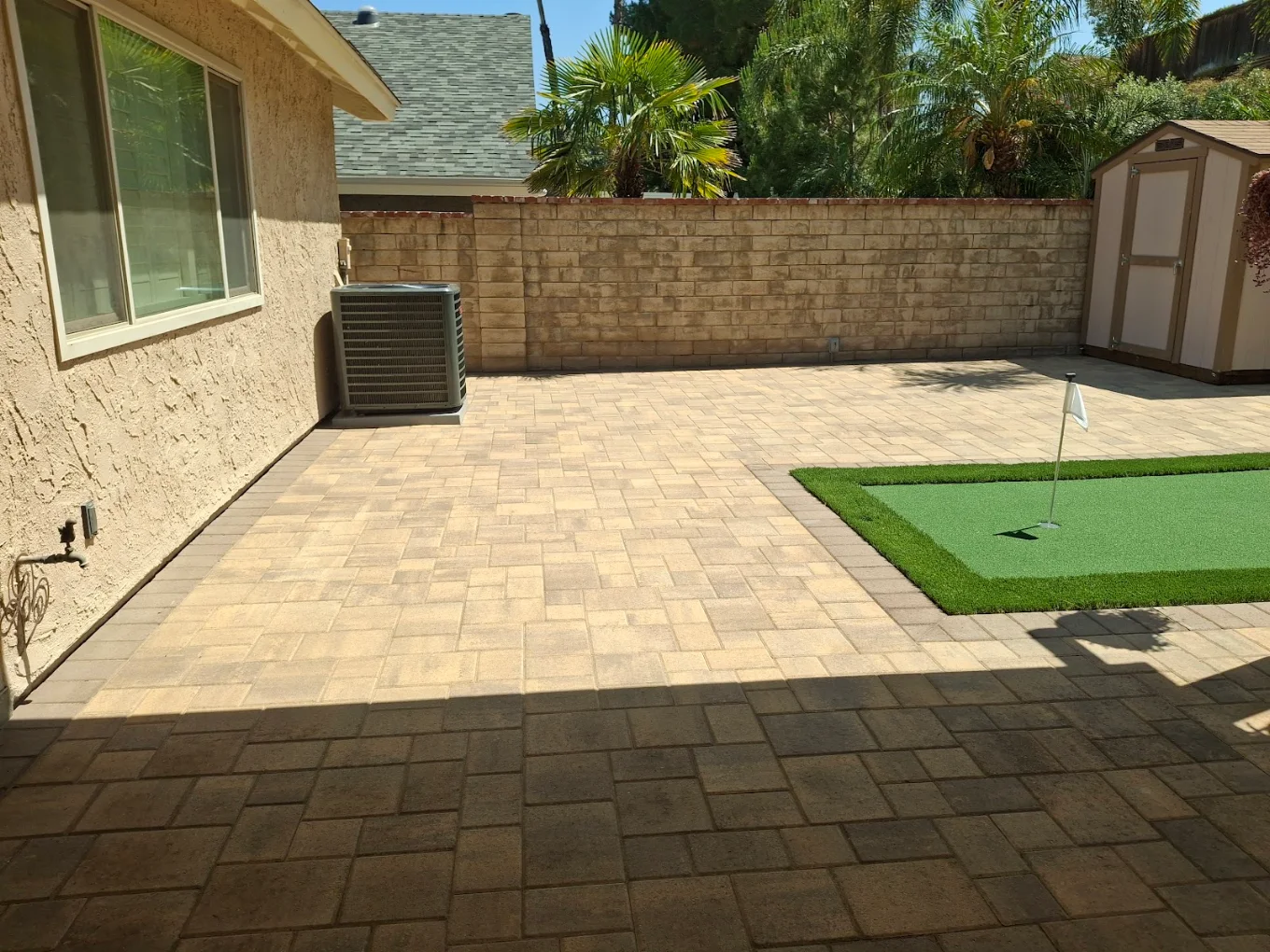 Backyard paver patio with a putting green in Clairemont